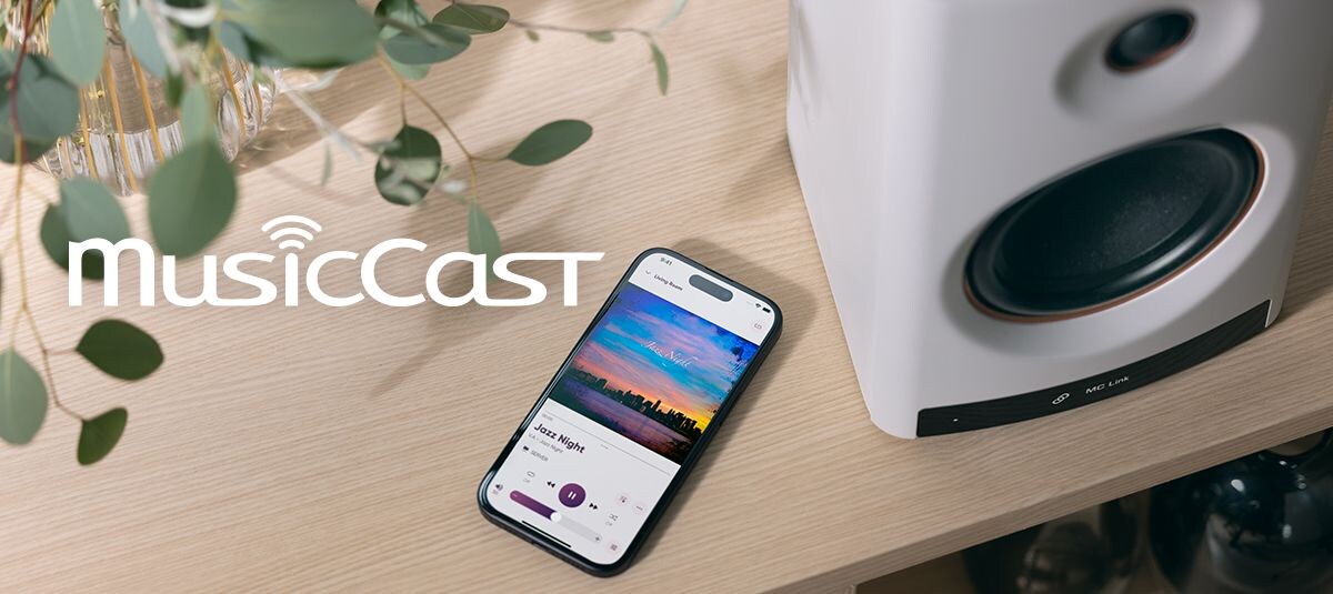 NX‑70A（W)ホワイトとスマートフォンの画像。スマートフォンの画面はMusicCast Controllerアプリ。
