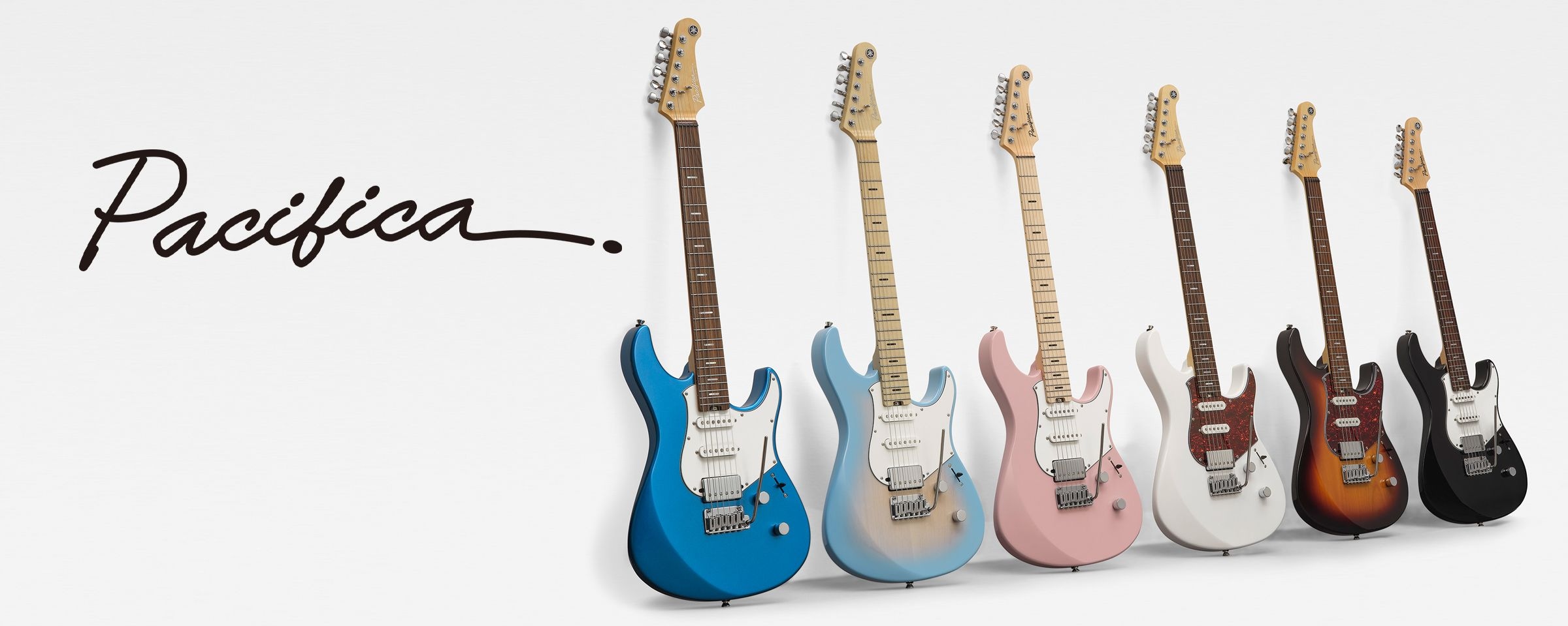 Family photo of Pacifica Professional and Standard Plus guitars leaning against a white background.