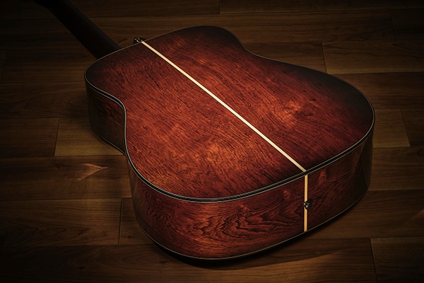 ヤマハギター60周年記念FG9が、側・裏板のグアテマランローズウッドの木目が良く見えるよう、床の上に横たえられている。