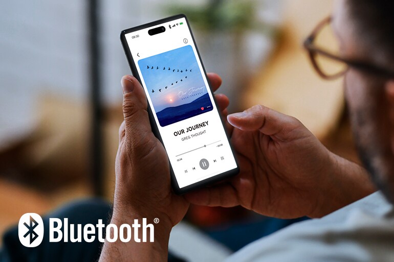 Bluetoothロゴと眼鏡をかけた男性がスマートフォンを捜査している画像