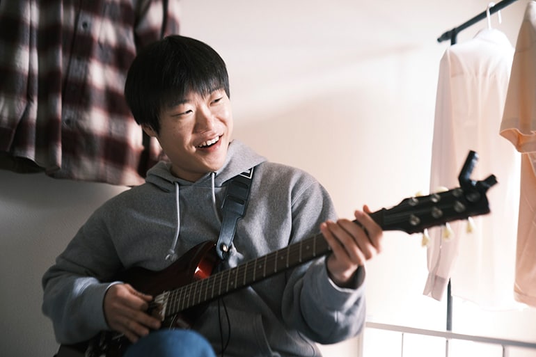初めてエレキギターを弾こうとする男性