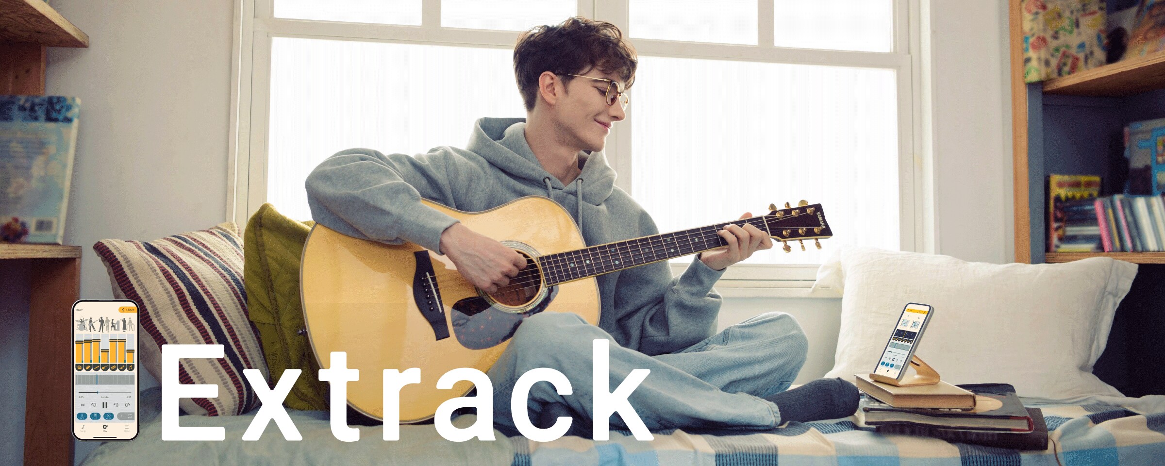 ソファに座り楽器アプリ「Extrack（エクストラック）」でセッションしながらギター練習を楽しむ男性