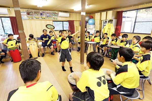クラブハウスにてドラムサークルを楽しむ、野寄さん担当の小学４年生のスクール生たち。